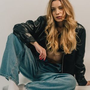 Buneri.es | Chaqueta de Cuero o Chaqueta Vaquera: ¿Cuál Elegir? Fashion-forward woman sitting casually in denim and leather jacket